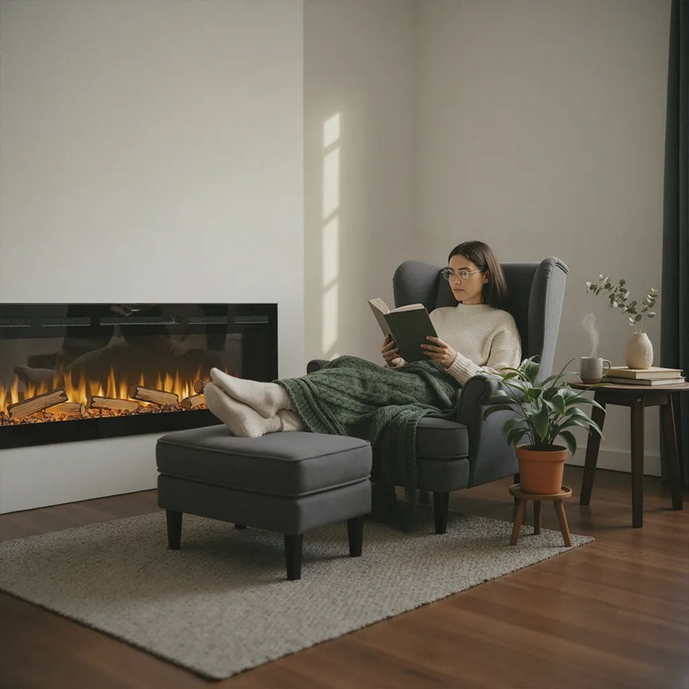 Woman reading a book in a cozy living room with a fireplace.
